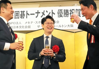 第７２回ＮＨＫ杯テレビ囲碁トーナメントの優勝祝賀会で、関西棋院の池坊雅史理事長（右）らと歓談する余正麒八段（中央）＝６月２７日、大阪市内