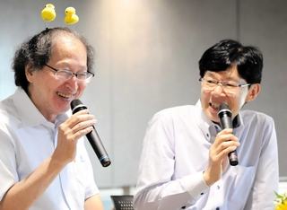 場を盛り上げようと、ひよこ形のカチューシャ姿で登場した福崎文吾九段（左）。谷川浩司十七世名人とタイトル戦での熱闘を振り返った＝５日、大阪府高槻市、関西将棋会館