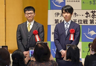 前夜祭でファンの写真撮影に応じる藤井聡太王位（右奥）と永瀬拓矢九段（左奥）＝１４日午後、神戸市北区有馬町、有馬グランドホテル（撮影・笠原次郎）
