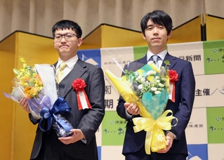前夜祭で花束を手にする藤井聡太王位（右）と永瀬拓矢九段＝１４日午後、神戸市北区有馬町、有馬グランドホテル（撮影・丸山桃奈）