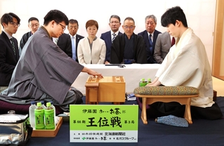 第３局で初手を指す永瀬拓矢九段（手前左）。手前右は藤井聡太王位＝29日午前、北海道千歳市、ポルトムインターナショナル北海道