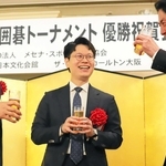 第７２回ＮＨＫ杯テレビ囲碁トーナメントの優勝祝賀会で、関西棋院の池坊雅史理事長（右）らと歓談する余正麒八段（中央）＝６月２７日、大阪市内