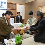 立会人の福崎文吾九段（右端）に封じ手を渡す永瀬拓矢九段（左）。右から２人目は藤井聡太王位＝１５日午後、神戸市北区有馬町、中の坊瑞苑（撮影・風斗雅博）