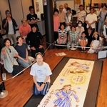 完成した作品を前に、観客と記念撮影に臨む漫画家こうの史代＝京都府福知山市東中ノ町