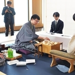 立会人の島朗九段（左）が示した封じ手を指す永瀬拓矢九段（中央）。右は藤井聡太王位＝３０日午前、北海道千歳市、ポルトムインターナショナル北海道