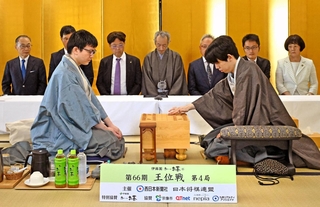 第４局で初手を指す藤井聡太王位（右）。左は永瀬拓矢九段＝１９日午前、福岡県宗像市、宗像ユリックス