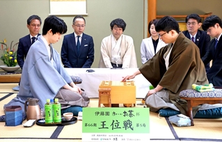 第５局で初手を指す永瀬拓矢九段（手前右）。左は藤井聡太王位＝２６日午前、徳島市、渭水苑