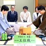 第５局で初手を指す永瀬拓矢九段（手前右）。左は藤井聡太王位＝２６日午前、徳島市、渭水苑