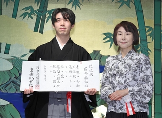 就位状を手にする藤井聡太王位（左）と日本将棋連盟の清水市代会長＝７日午前、明治記念館