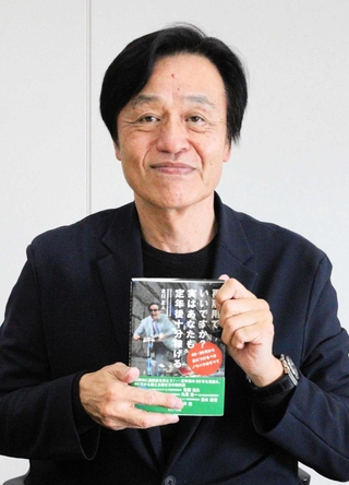 新著を手に、「定年を機に充実した老後を送ってほしい」と話す北口正人さん＝神戸新聞社