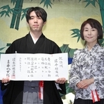 就位状を手にする藤井聡太王位（左）と日本将棋連盟の清水市代会長＝７日午前、明治記念館