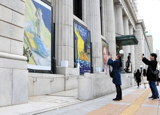 大ゴッホ展の垂れ幕がかかる正面出入り口では、前を通る人が足を止め、写真を撮っている＝神戸市立博物館