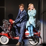 愛車のスクーターに乗るアレックス（左、暁千星）とシンシア（詩ちづる）＝宝塚大劇場