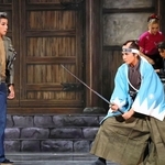 高阪坂左衛門（鳳月杏、右）は殺陣師の関本（輝月ゆうま）に教えを請う＝大阪府箕面市