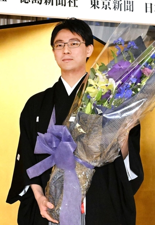 花束を手にする一力遼天元＝４日午後、東京都千代田区、日比谷松本楼