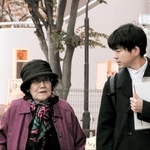 ９４歳の岸明子さん（左）に話を聞く２７歳の山中健一記者