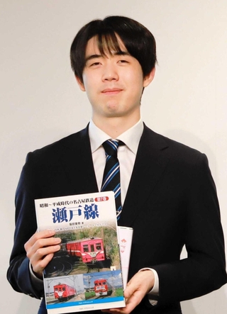 関西囲碁将棋記者クラブ賞の副賞として、鉄道の本を贈られた藤井聡太六冠＝１８日、関西将棋会館