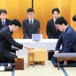 開幕局で初手を指す森本才跳四段（手前左）と生垣寛人四段（同右）＝１６日、加古川市加古川町溝之口