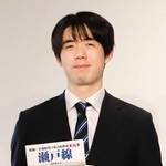 関西囲碁将棋記者クラブ賞の副賞として、鉄道の本を贈られた藤井聡太六冠＝１８日、関西将棋会館