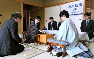 立会人の福崎文吾九段（左）から封じ手を示され、着手する伊藤匠二冠（中央）。右は藤井聡太王位＝１６日午前９時１分、神戸市北区有馬町、中の坊瑞苑（撮影・風斗雅博）