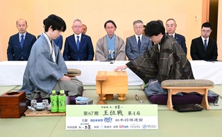 第４局で初手を指す伊藤匠二冠（手前右）。手前左は藤井聡太王位＝１８日午前９時、長崎市、ガーデンテラス長崎ホテル＆リゾート
