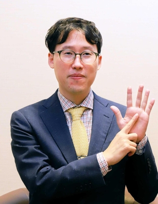 碁聖戦６連覇にちなんだポーズをとり、撮影に応じた井山裕太碁聖＝２１日、日本棋院関西総本部