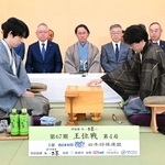 第４局で初手を指す伊藤匠二冠（手前右）。手前左は藤井聡太王位＝１８日午前９時、長崎市、ガーデンテラス長崎ホテル＆リゾート