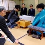 立会人の中田功八段（左）が読み上げた封じ手を指す藤井聡太王位（左から２人目）。右から２人目は伊藤匠二冠＝２７日午前、徳島市、渭水苑