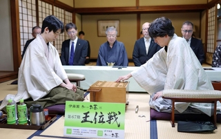 第６局で初手を指す伊藤匠二冠（手前右）。手前左は藤井聡太王位＝８日午前、神奈川県秦野市、元湯陣屋