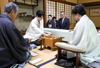 立会人の青野照市九段（左）が読み上げた封じ手を指す藤井聡太王位（左から２人目）。右は伊藤匠二冠＝９日午前、神奈川県秦野市、元湯陣屋