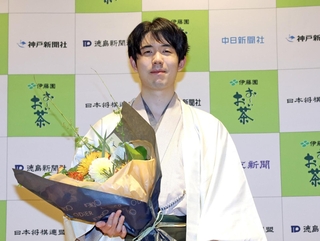 王位戦で７連覇を達成し、花束を手に記念撮影に応じる藤井聡太王位＝９日午後、神奈川県秦野市、元湯陣屋