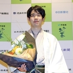 王位戦で７連覇を達成し、花束を手に記念撮影に応じる藤井聡太王位＝９日午後、神奈川県秦野市、元湯陣屋