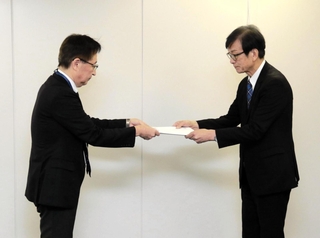 神戸市室内管弦楽団の存続に向けた提案書を市文化スポーツ局の三重野雅文局長（左）に手渡す神戸市民文化振興財団の服部孝司理事長＝２日午前、神戸市役所