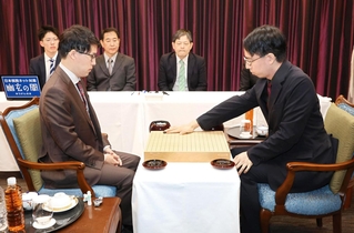第１局で第一着を打つ一力遼天元（右）。左は井山裕太碁聖＝７日午前、名古屋市中区、名古屋東急ホテル