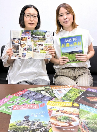 毎月のおでかけ手帳を前に、本になった「おでかけ手帳兵庫の休日」を手にする牧野しのぶさん（左）と井鍋槙さん＝大阪市内