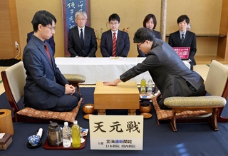 第２局で初手を打つ井山裕太碁聖（右）。左は一力遼天元＝20日午前、札幌市中央区、京王プラザホテル札幌