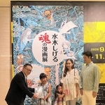１万人目の入館者となり、記念品を受け取る髙塚凛さんと家族＝９日、神戸ファッション美術館