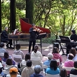 木漏れ日が美しい野外ステージで演奏するマウロ・イウラートさん（奥中央）ら＝神戸市灘区六甲山町（撮影・風斗雅博）