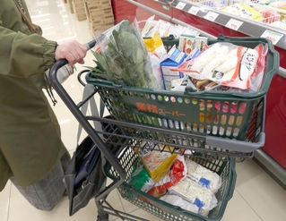 大容量の冷凍食品などで一杯になった来店客の買い物かご＝神戸市西区、業務スーパー伊川谷店