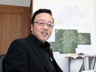 新たに立ち上げた会社の自室で笑顔を見せる沼田昭二氏＝加古川市平岡町新在家、町おこしエネルギー
