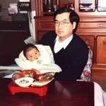 １９８８年、父禎史氏に抱かれる生後３カ月の大村浩一氏（西松屋チェーン提供）