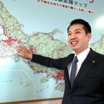 店舗を示す赤い印で染まる日本地図を指し示し、さらなる成長を誓う西松屋チェーンの大村浩一社長＝姫路市飾東町庄（撮影・辰巳直之）