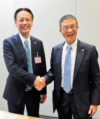 ２０１８年、トップ交代の発表で握手を交わすロック・フィールドの古塚孝志社長（左）と岩田弘三会長（同社提供）
