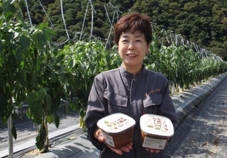 ピーマン畑で「矢田川みそ」を手にする今井裕子さん＝兵庫県香美町村岡区原