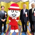 会社の７０周年記念式典で公式キャラクター「Ｑちゃん」と並ぶ副社長時代の塚本浩康社長（左端）と父の哲夫氏（中央）、当時３代目社長だった三宅宏和会長（いずれも六甲バター提供）