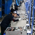 全長１０８メートルのラインで組み上げられる給湯器。手際よい作業が続く＝いずれも明石市二見町南二見、ノーリツ明石本社工場（撮影・斎藤雅志）