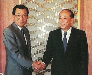 合併が決まり、握手する末松謙一・三井銀行社長（左）と松下康雄・太陽神戸銀行頭取。平成の幕開けを告げた大合併だった＝１９８９年８月、東京・虎ノ門
