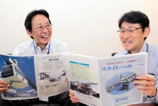 当時の資料を手に、スカイレール開発の思い出を語り合う神戸製鋼所の小屋和弥さん（左）と大杉仁さん＝神戸市中央区脇浜海岸通２