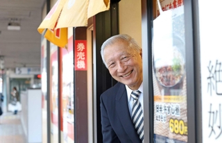 ＪＲ姫路駅の乗降客らに長年愛されるえきそばの歴史について語るまねき食品の竹田佑一会長＝姫路市駅前町、ＪＲ姫路駅（撮影・小林良多）