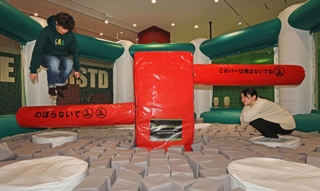 回転するバーを跳びはねたり、しゃがんだりしてかわすアトラクション「Ｊｕｍｐ×Ｊｕｍｐ」＝２９日午前、神戸市東灘区向洋町中２、神戸スーパースタジアム（撮影・笠原次郎）